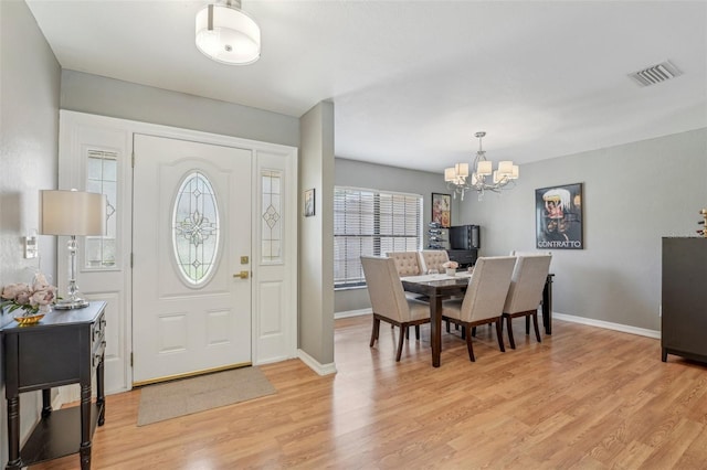 foyer featuring visible vents, baseboards, light wood-style flooring, and a notable chandelier