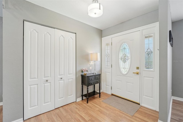 foyer entrance featuring baseboards and light wood-style floors