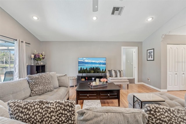 living area with recessed lighting, visible vents, light wood-style flooring, vaulted ceiling, and baseboards