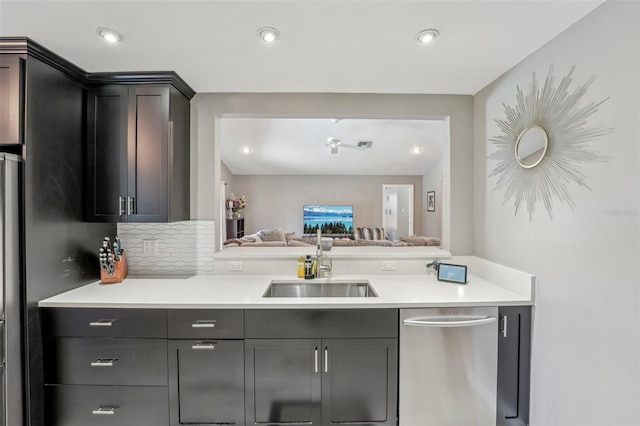 kitchen featuring backsplash, light countertops, a sink, and open floor plan