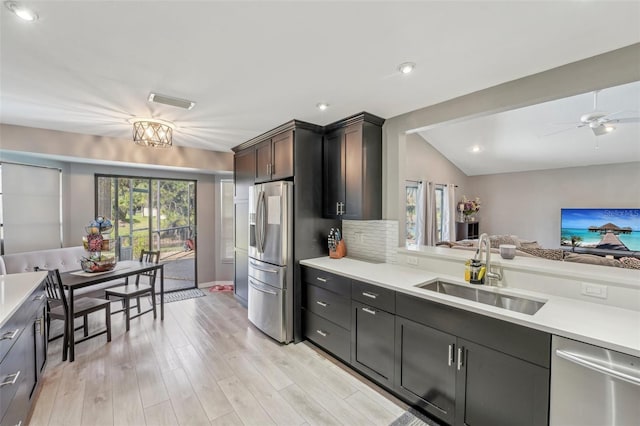 kitchen with dark brown cabinets, appliances with stainless steel finishes, light countertops, and a sink