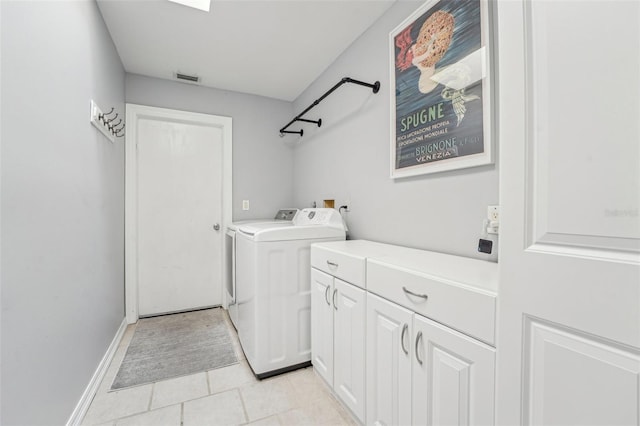 laundry area featuring light tile patterned floors, washing machine and dryer, visible vents, baseboards, and cabinet space