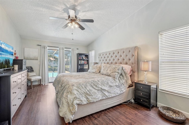 bedroom featuring lofted ceiling, dark wood-style flooring, a textured ceiling, and access to exterior