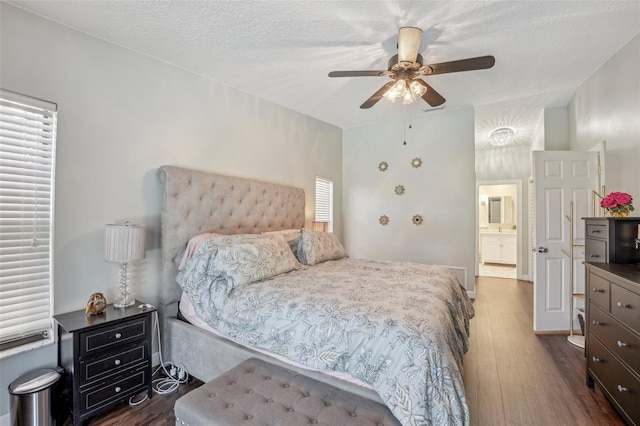 bedroom featuring dark wood-style floors, a ceiling fan, and a textured ceiling