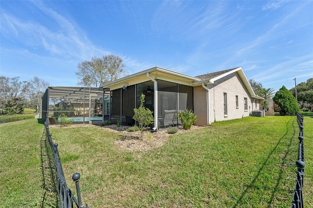 view of home's exterior featuring glass enclosure, a yard, central AC unit, and an outdoor pool