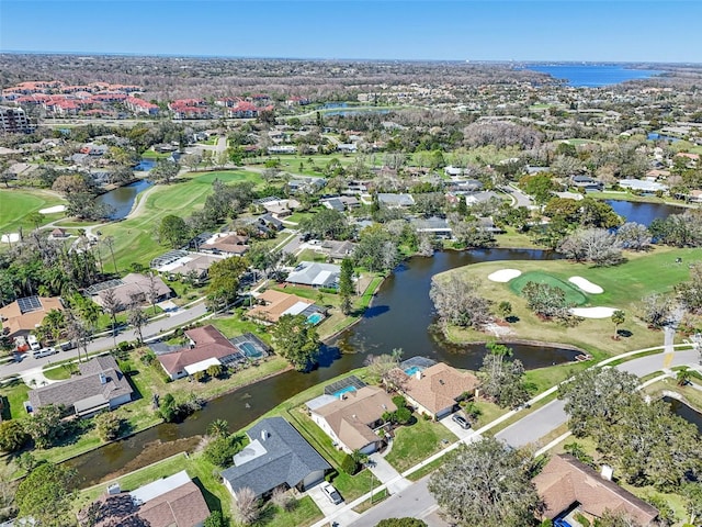 aerial view with view of golf course, a water view, and a residential view