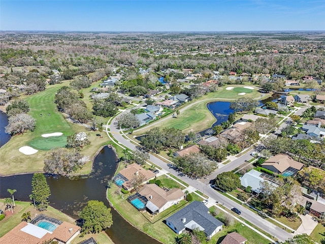 drone / aerial view featuring view of golf course, a water view, and a residential view