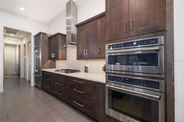 kitchen with tasteful backsplash, visible vents, wall chimney exhaust hood, appliances with stainless steel finishes, and light countertops