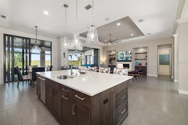 kitchen featuring a center island with sink, light countertops, visible vents, open floor plan, and a sink