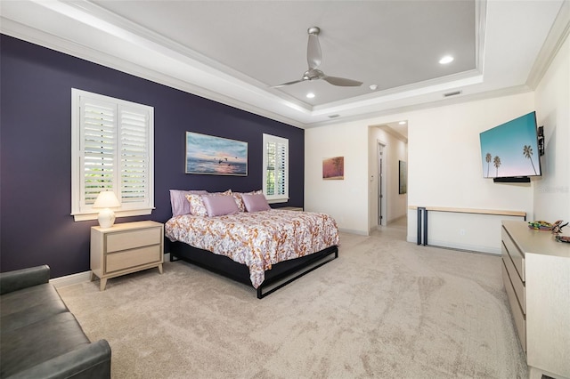 bedroom featuring a tray ceiling, light colored carpet, crown molding, and baseboards