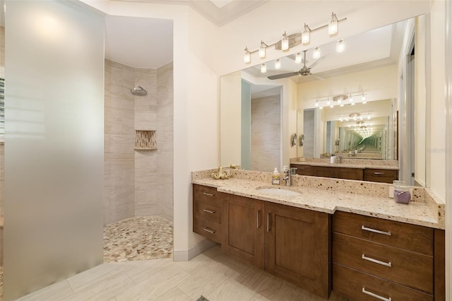 full bath featuring crown molding, ceiling fan, vanity, and walk in shower