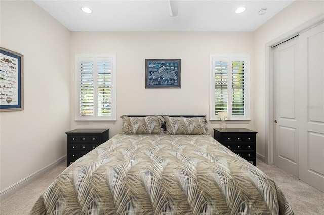 bedroom featuring light carpet, a closet, and baseboards