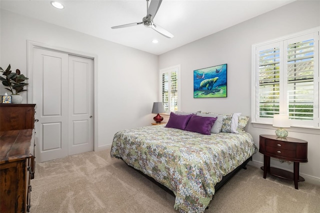 bedroom with ceiling fan, recessed lighting, light carpet, baseboards, and a closet