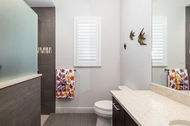 full bath with toilet, baseboards, and vanity