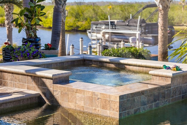 view of swimming pool featuring a water view and an in ground hot tub