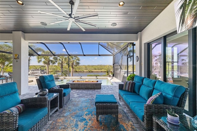 view of patio / terrace featuring a hot tub, a ceiling fan, a lanai, a water view, and outdoor lounge area