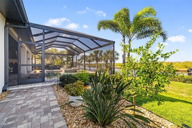 view of patio with a water view and a lanai