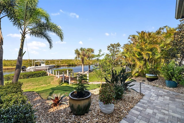 view of yard featuring a water view, boat lift, and a dock