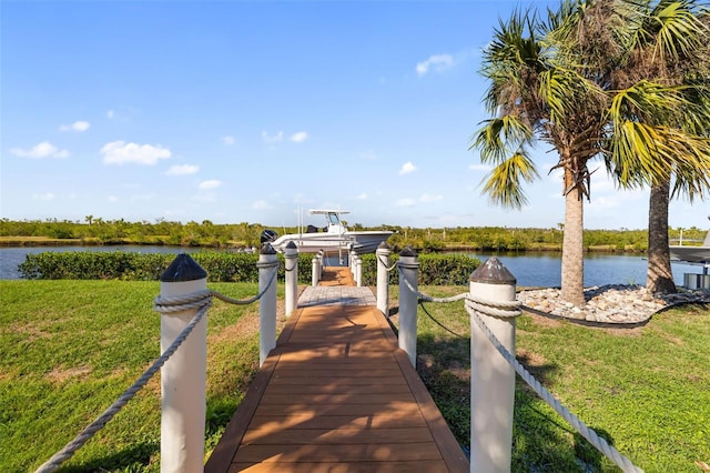 dock area featuring a water view, a yard, and boat lift