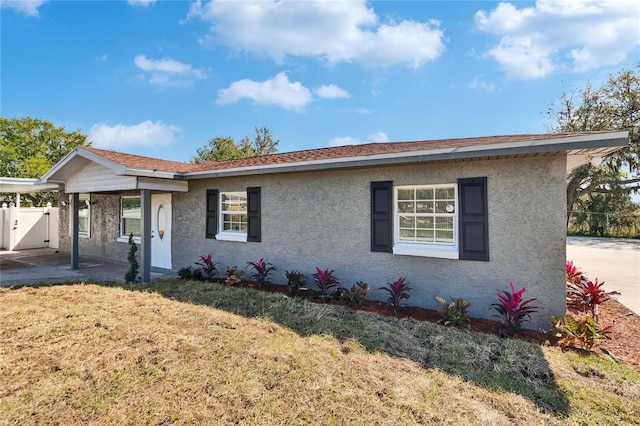 view of front facade with a front yard, fence, and stucco siding