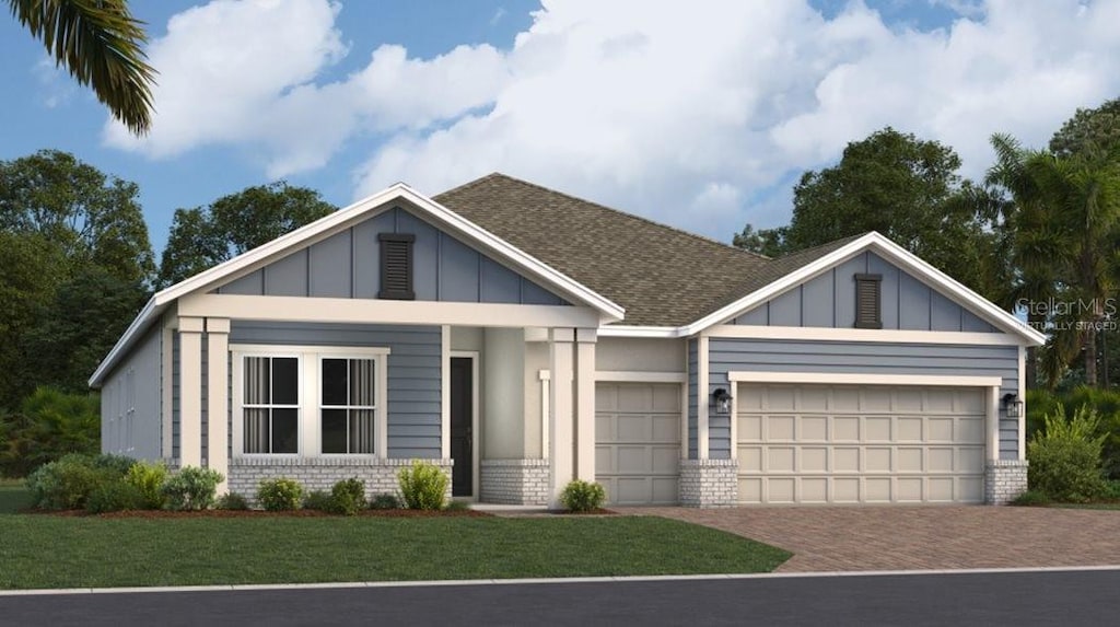1919 Rider Rain Ln, Apopka, FL 32703 - view of front facade with a garage, brick siding, board and batten siding, and decorative driveway