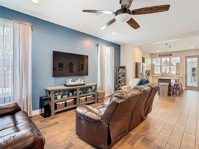 living room featuring recessed lighting, baseboards, light wood-style floors, and ceiling fan