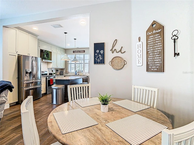 dining area featuring visible vents, recessed lighting, and dark wood-style flooring