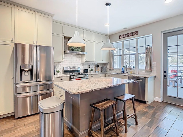 kitchen featuring a sink, stainless steel appliances, tasteful backsplash, and a healthy amount of sunlight