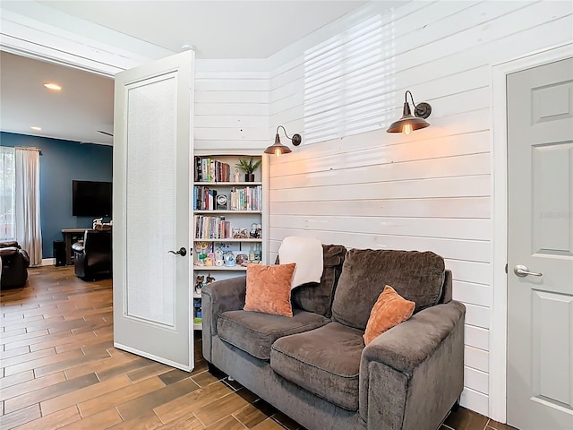 sitting room with wood finished floors and wood walls