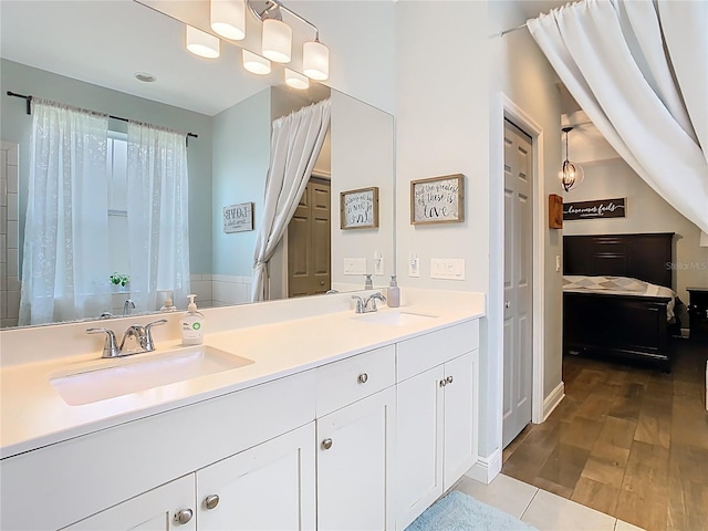 full bathroom featuring a sink, wood finished floors, and double vanity