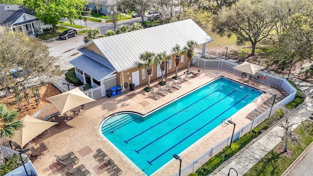 community pool with a patio area and fence