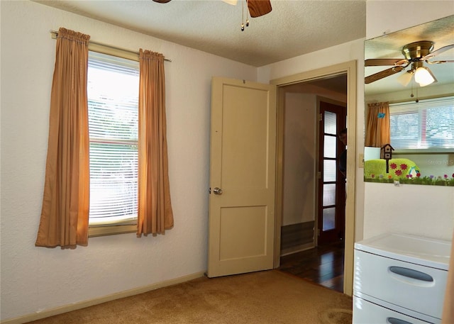 interior space featuring baseboards, a textured ceiling, a wealth of natural light, and a ceiling fan