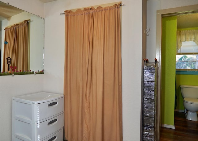 bathroom featuring wood finished floors and toilet