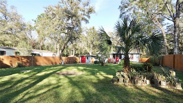 view of yard with a fenced backyard and an outbuilding