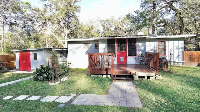 view of front of house with metal roof, a front yard, fence, and a wooden deck