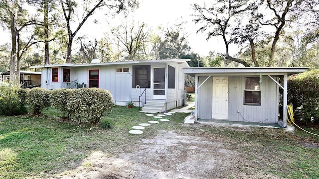 view of front of house featuring entry steps and a front lawn