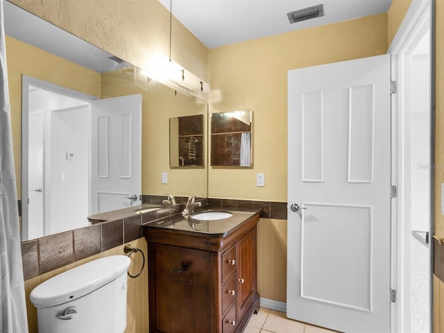 full bath featuring tile walls, visible vents, toilet, vanity, and tile patterned flooring