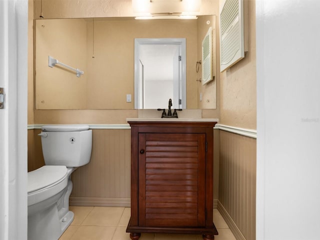 half bathroom featuring toilet, vanity, and tile patterned floors