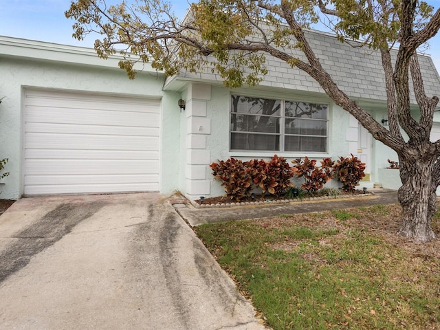 view of front of property with an attached garage, roof with shingles, concrete driveway, and stucco siding