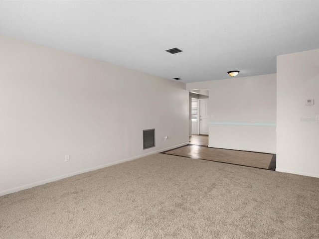 empty room featuring carpet flooring, visible vents, and baseboards