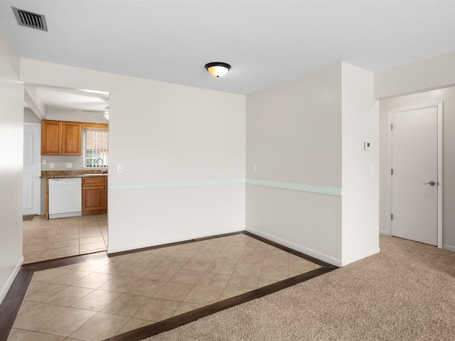 spare room featuring light tile patterned floors, light carpet, visible vents, and baseboards