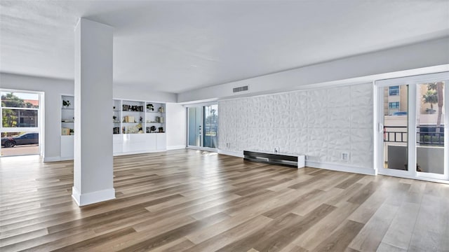 855 Bayway Blvd Unit 105, Clearwater, FL 33767 - unfurnished living room with plenty of natural light, wood finished floors, and baseboards