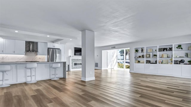 855 Bayway Blvd Unit 105, Clearwater, FL 33767 - unfurnished living room featuring wood finished floors, recessed lighting, baseboards, and a fireplace