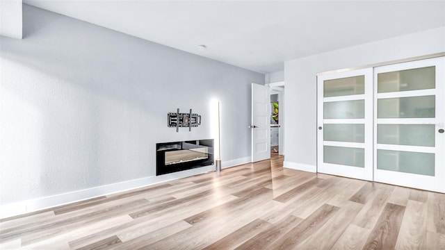 855 Bayway Blvd Unit 105, Clearwater, FL 33767 - spare room with wood finished floors, a glass covered fireplace, and baseboards