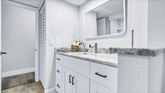 855 Bayway Blvd Unit 105, Clearwater, FL 33767 - bathroom with vanity, baseboards, and wood finished floors