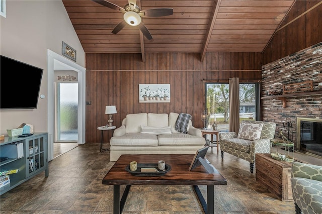 living area featuring lofted ceiling with beams, wood ceiling, wooden walls, and a ceiling fan