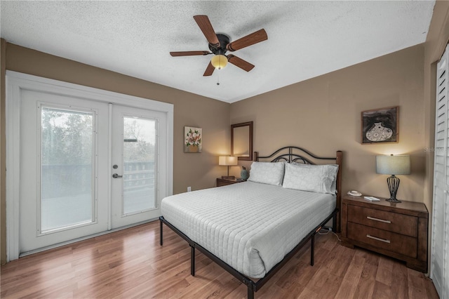 bedroom featuring a textured ceiling, access to outside, wood finished floors, and a ceiling fan