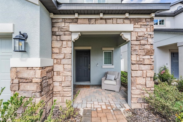 doorway to property with stone siding and stucco siding