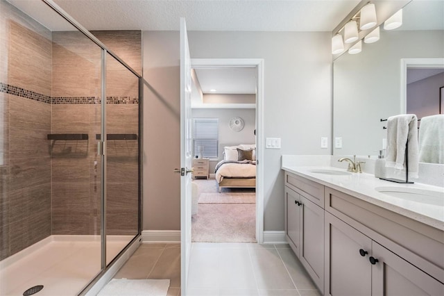 ensuite bathroom featuring double vanity, a stall shower, tile patterned floors, ensuite bathroom, and a sink