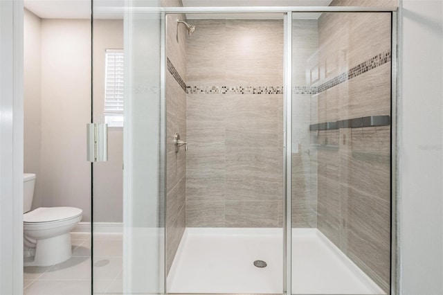 bathroom featuring toilet, a stall shower, and tile patterned flooring